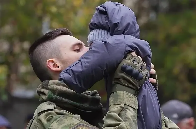 солдат держит на руках ребенка